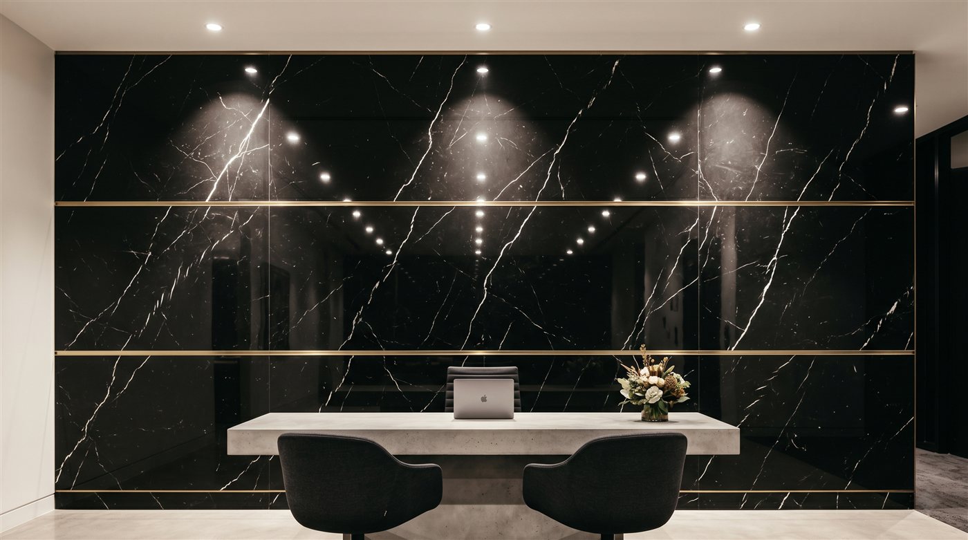 Black marble reception desk with gold inlay in commercial office